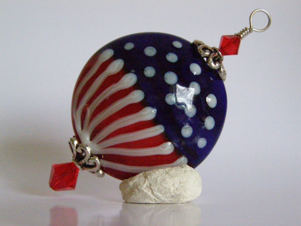 Handmade glass large patriotic lentil bead in a pendant.